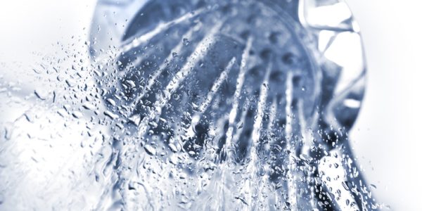 Shower with running water against glass
