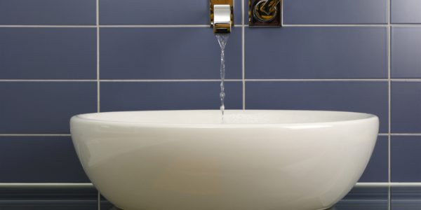 Sink in the bathroom standing on a glass shelf with modern pipe on the wall.Similar images: