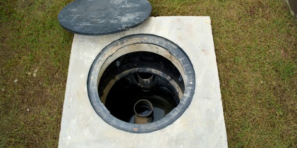 A hole of grease trap with the drain system around the house.