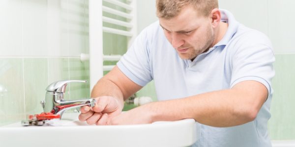 A construction plumber installing bathroom fixtures